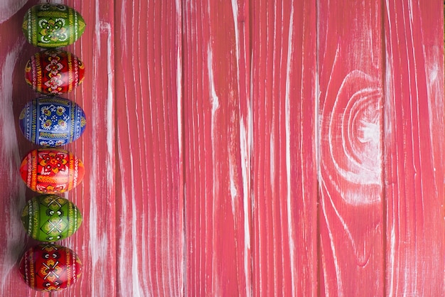 Бесплатное фото Декоративные пасхальные яйца на розовой деревянной поверхности
