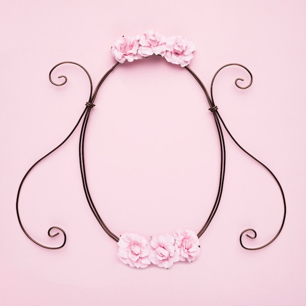 Free photo decorative empty frame with roses on pink wall