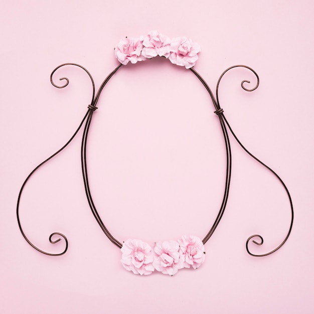 Decorative empty frame with roses on pink wall