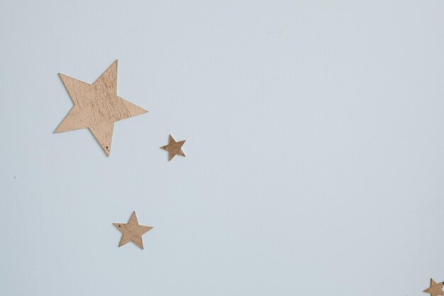 Decorative golden stars on the wall Closeup of decorative golden paper stars of different size on plain blue wall like sky