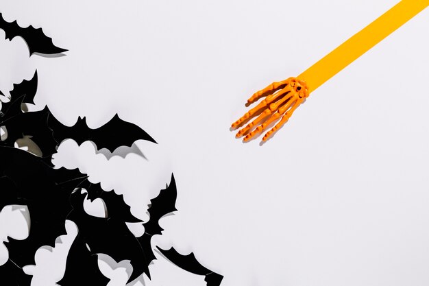 Decorative Halloween bats near skeleton hand