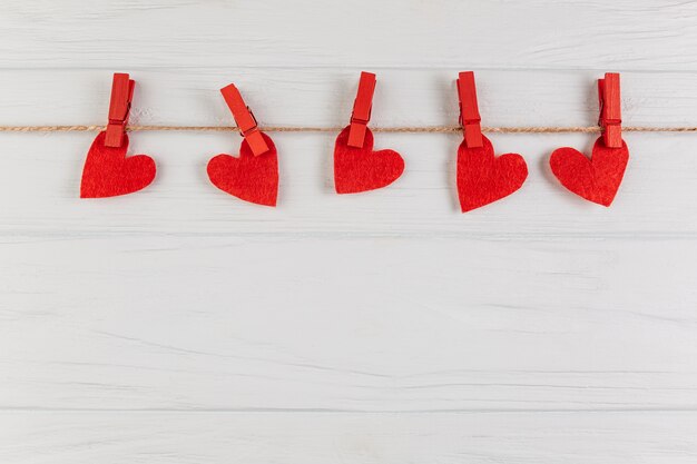 Decorative hearts hanging on rope with pegs