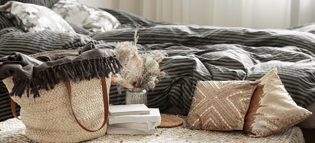 Decorative items in a cozy home interior. Wicker straw large bag, and decorative elements.