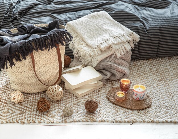 Декоративные элементы в уютном домашнем интерьере с помощью большой плетеной соломенной сумки и элементов декора.