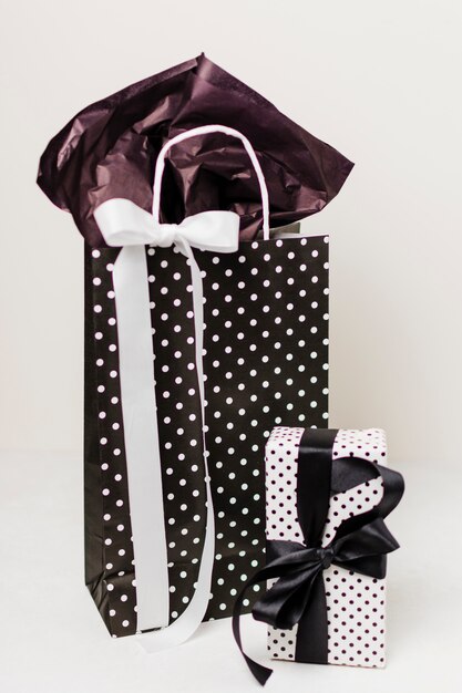 Decorative paper bag and beautiful gift box against white backdrop