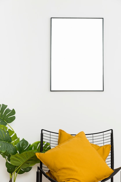 Decorative plant with empty frame and chair