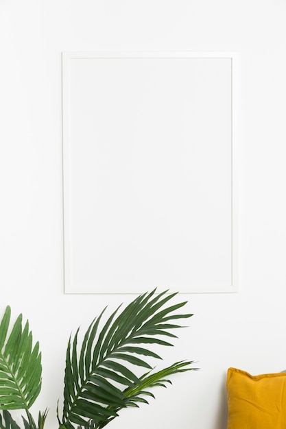 Decorative plant with empty frame and cushion