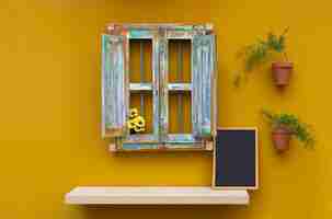 Free photo decorative retro window with plants on yellow wall