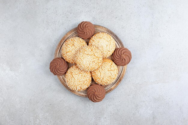 Decorative stack of homemade cookies on wooden tray, on marble background. High quality photo