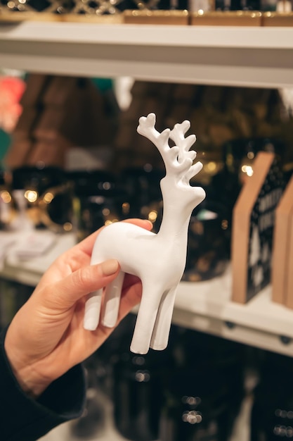 Бесплатное фото Декоративная статуя оленя в женских руках в магазине