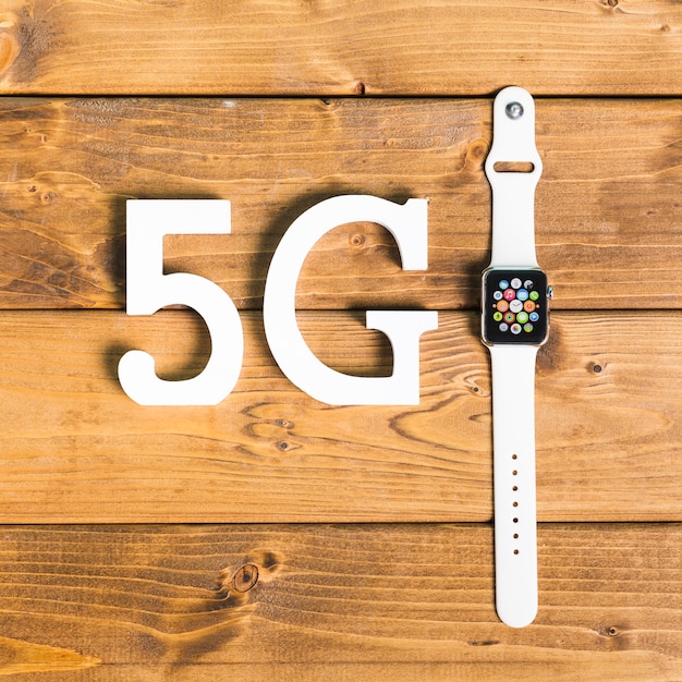 Decorative symbols 5G and smart watch on desk