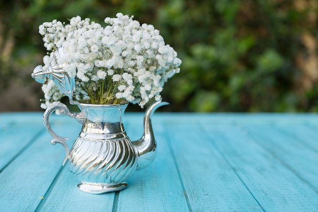 Free photo decorative teapot full of white flowers