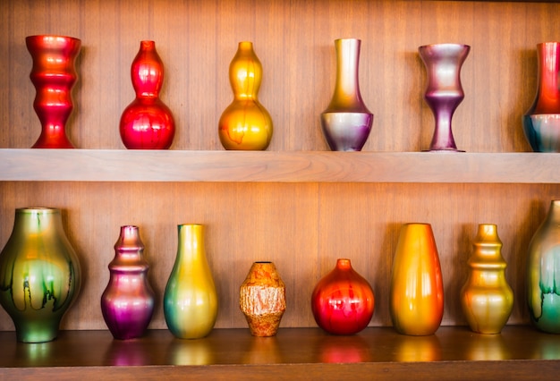 Decorative vases  on wooden shelf .