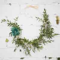 Free photo decorative wreath attached on white brick wall