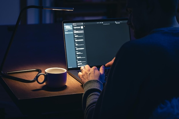 Free photo dedicated businessman working late at laptop in dark office