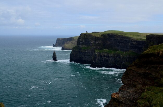 Deep blue waters crashing into the Cliffs of Moher