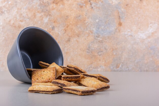 Deep bowl with chocolate filled biscuits on white background. High quality photo