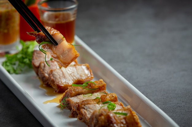 deep fried pork belly with fish sauce on dark background