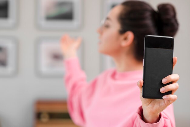 Defocused blogger holding her phone