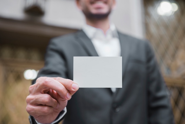 Defocused businessman showing white visiting card