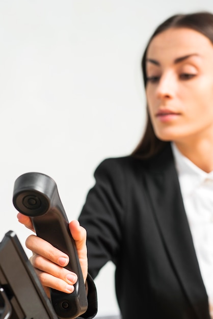 Free photo defocused businesswoman holding black telephone receiver