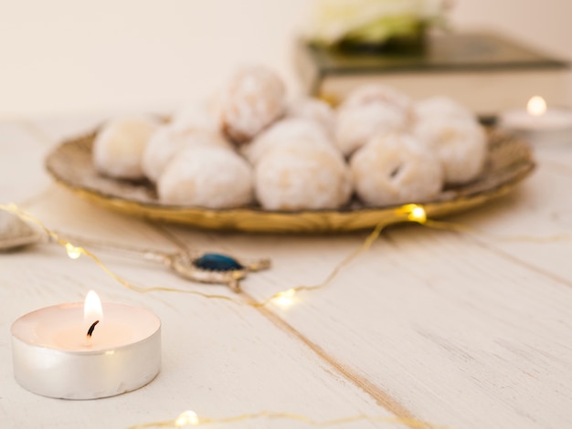 Free photo defocused cookie plate with candle and quran