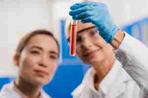 Free photo defocused female scientists analyzing substance in the lab