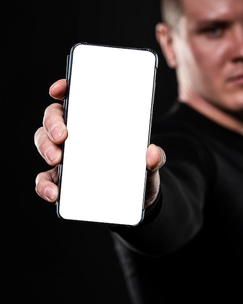 Defocused male rugby player holding smartphone
