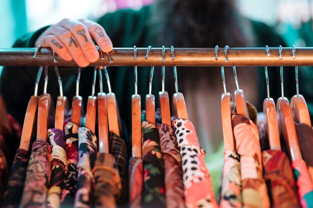 Defocused man choosing shirt hanging on the rail in the shop