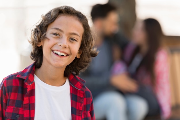 Defocused parents with smiley child outdoors