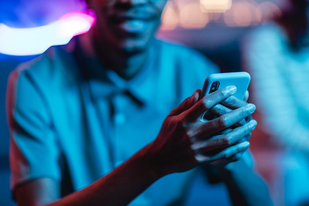 Defocused smiley man holding smartphone in hands