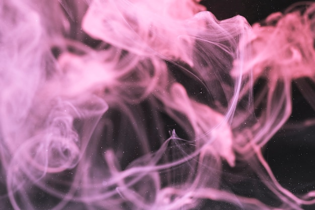 Defocused violet smoke on black screen