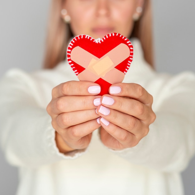 Defocused woman holding fixed heart