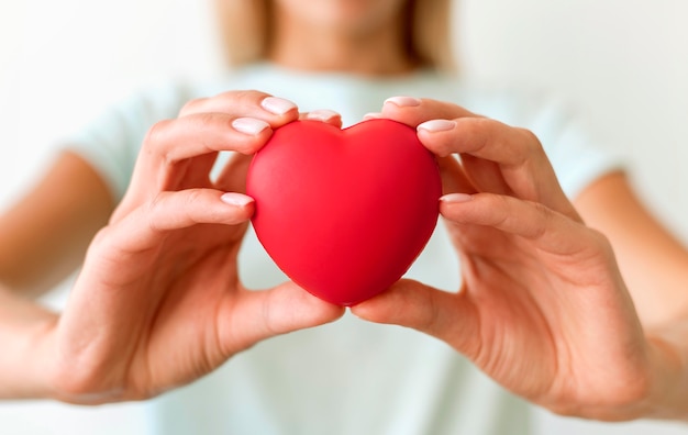 Defocused woman holding heart shape