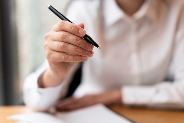 Defocused woman showing pen close up