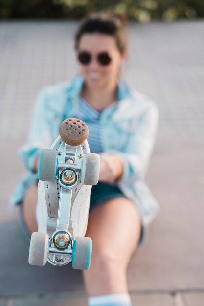 Defocussed young woman showing foot with roller skate
