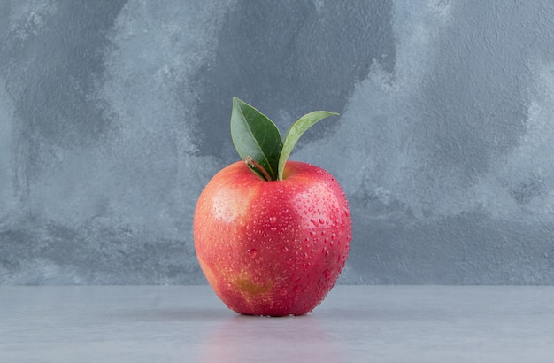 A delectable apple displayed on marble . 