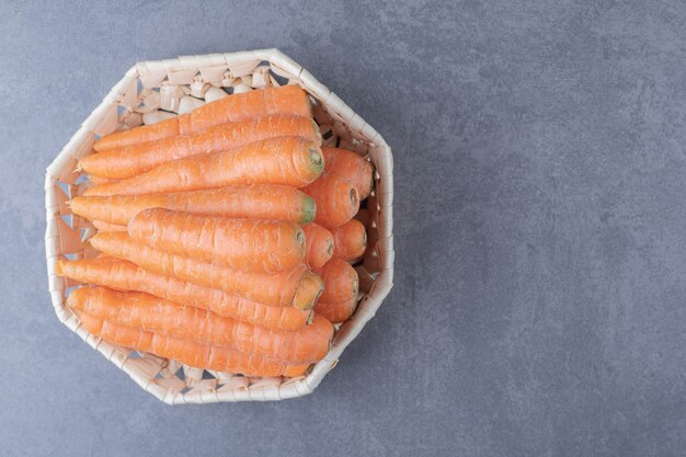 Delectable carrots in the bowl , on the marble surface.