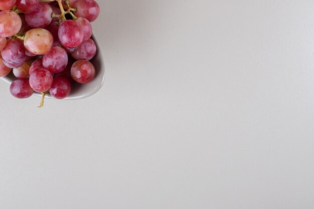 A delectable cluster of red grapes on marble 