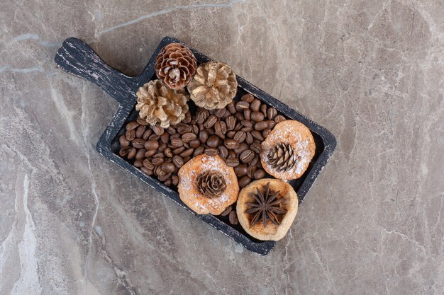 Delectable cookies. anise, coffee beans and pine cones on marble. 