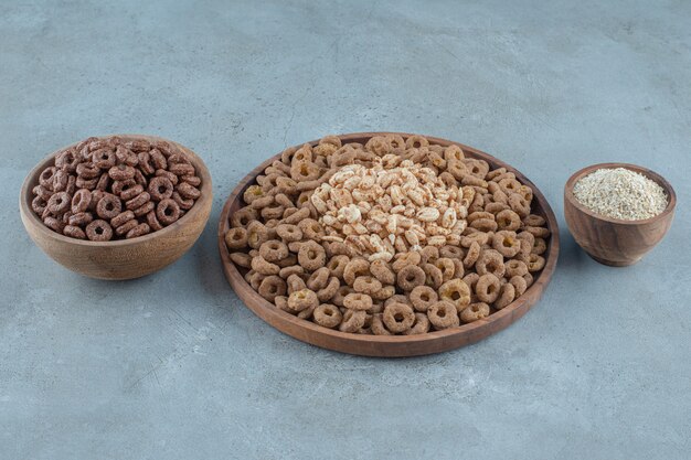 Delectable cornflakes in the wooden bowls , on the blue background. High quality photo