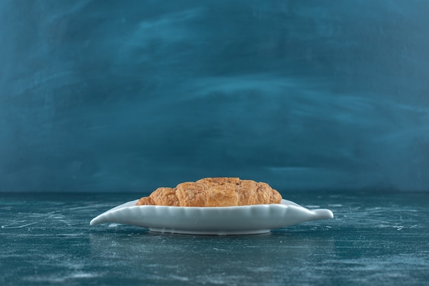 Delectable croissant on a platter , on the blue background. High quality photo