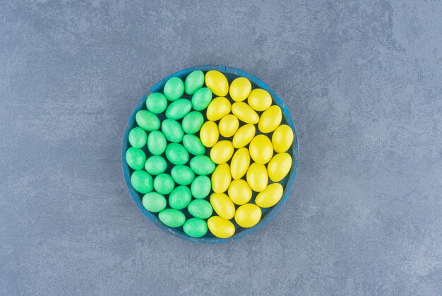 Delectable gums in the bowl, on the marble background. 