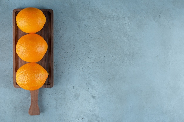 Delectable oranges on a board , on the marble table. 