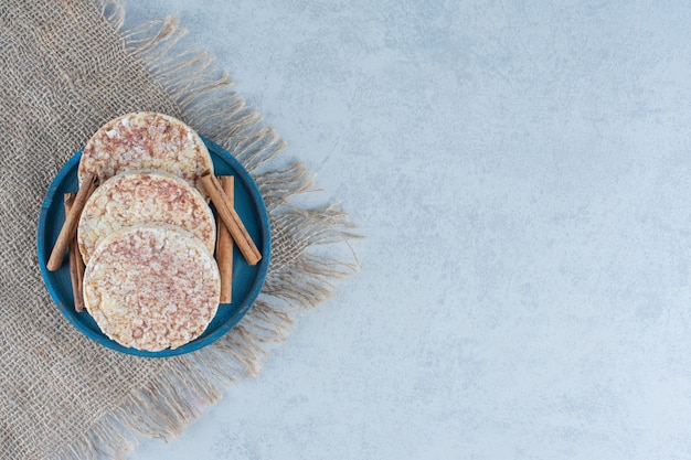 Deliziose torte di riso e piatto di legno su marmo