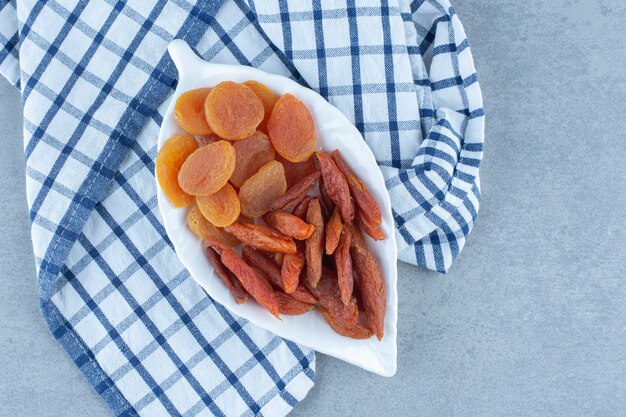 맛있는 두 종류의 말린 과일, 그릇, 수건, 대리석 테이블.