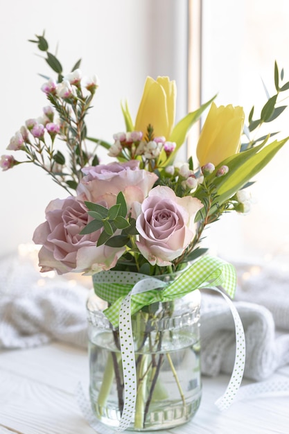 Delicate bouquet of spring flowers in a vase on the windowsill