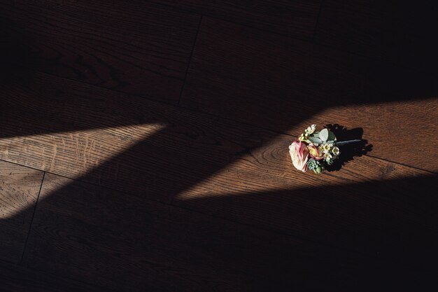 Delicate boutonniere made of roses lies on the windowsill