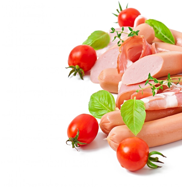 Delicate meats (sausage and ham) decorated with basil and tomatoes isolated 