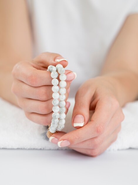 Delicate woman's hands holding beads